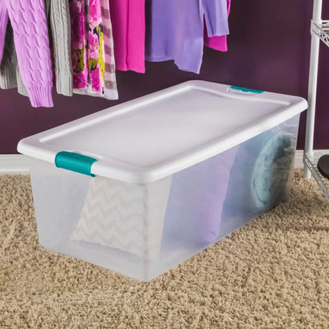 Slay Your Storage Goals With This Badass Set Of Plastic Latching Storage Bins Featuring Secure Snap Lids, Includes 106 Qt And 64 Qt Totes For Closet Decluttering, Garage Organization, And Keeping Bugs At Bay. Clear plastic storage bin with lid, holding textured pillows, in a closet setting.