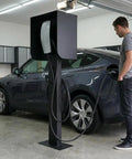 Man using All Weather EV Charger Pedestal With Roof And Side Protection Built To Last Indoor Outdoor Charging Stand in garage