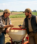 Two men discussing next to a broadcast spreader in a farm field, related to Spreader Replacement Parts With Extension Arm For Even Spreading And Uniform Mixing Upgraded Agitator Delivers Pro Grade Smooth Flow And No Clog Feeding In Industrial And Craft Settings.