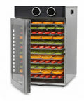 Heavy Duty Electric Food Dehydrator With Twelve Stainless Steel Trays And A Badass 1200 Watt Motor Providing 360 Degree Even Heat Circulation, filled with drying fruit.