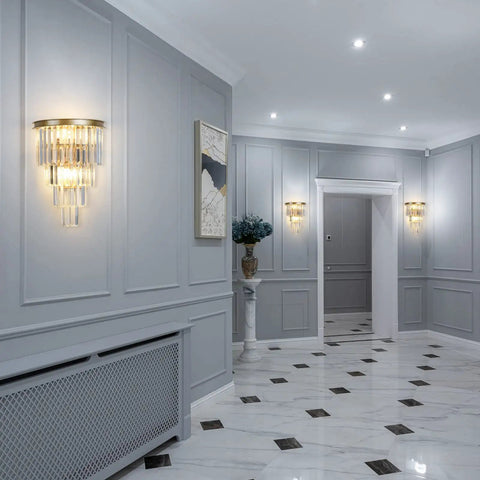 Slick Gold Crystal Four Tier Wall Sconce Lighting in a hallway, glowing warmly with K9 crystals on a modern gold fixture.