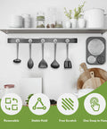 Front view of Neosmuk magnetic hook rail with five silver hooks hanging kitchen utensils beneath a white shelf.