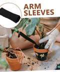 Snag This Badass Pair Of Cut Resistant Arm Sleeves And Heat Guards Designed For Gardening Welding Mechanics Or Carpentry To Keep Your Arms Cool Protected All Day Long. Black knit arm sleeves displayed with gardening plants.