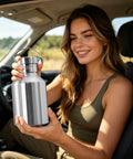 Person holding 2L Stainless Steel Travel Cup With Handle Wide Mouth Water Bottle For Hiking Fishing And Outdoor Sports in car