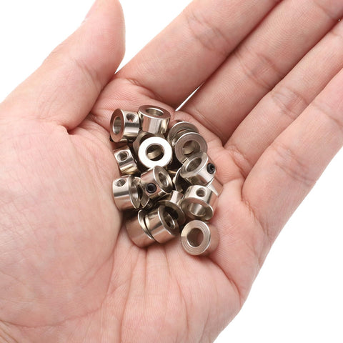 Hand holding twenty piece set screw shaft collars with 5.05mm bore, 10mm OD, 5mm width, nickel plated carbon steel drill stop collars.