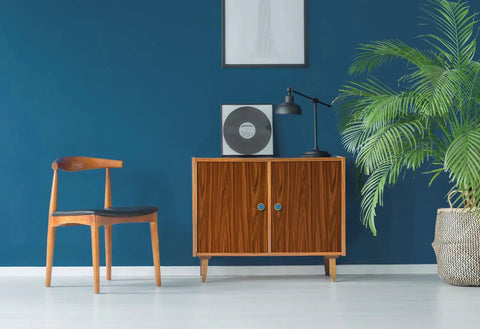 Gold Walnut Wood Effect Vinyl Wrap 45 Cm By 2 M Self Adhesive Contact Paper applied to furniture in a room with a blue wall and plants.