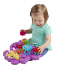 Child playing with Totally Awesome Dope Monkey Gears Stacking And Spinning Toy, placing colorful plastic cogs on a purple base.
