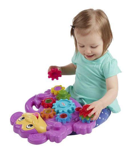 Child playing with Totally Awesome Dope Monkey Gears Stacking And Spinning Toy, placing colorful plastic cogs on a purple base.