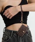 Streamlined Rfid Blocking Keychain Wallet With Genuine Leather Wrist Strap worn on wrist, showcasing leopard print design and card slots.