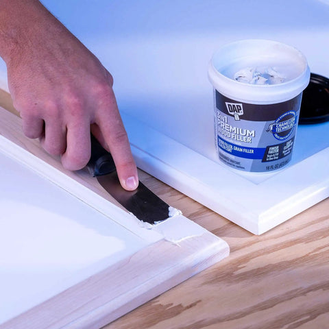 Applying Premium White Wood Filler 16 Oz 3 In 1 Stainable Grain Filler And Sealer Coat Pro Grade Acrylic Latex with putty knife