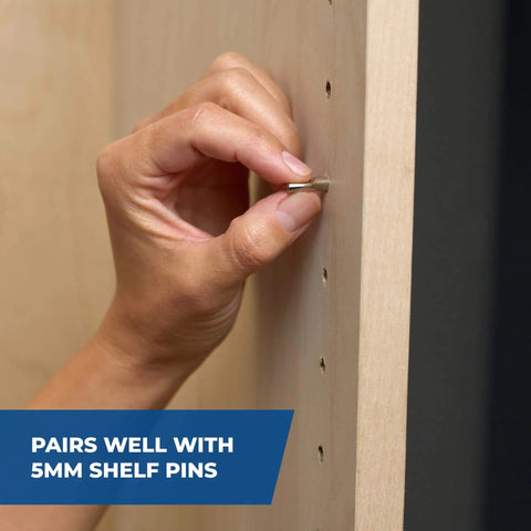 Hand placing shelf pin into wood with 5mm holes drilled using Pro Grade Shelf Hole Jig For Clean Wobble Free Shelves With Six Hardened Steel Drill Guides, Five Mm Hole Size, Increments Of One And A Quarter Inches, And A 32 Mm System, Durable Diy Woodworking Tool For Precise Shelving Installations