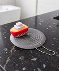 TEHAUX Silicone Bathtub Drain Stopper 6'', Hair Catcher for Bathroom on black countertop with playful boat design.