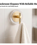 Kick Clutter To The Curb With This Slick Space Saving Wall Hook Designed To Ace Your Entryway Organization Game While Keeping Bathrooms And Bedrooms Tidy Without Taking Up Any Extra Room, featuring a gold metal hook on a striped acrylic background holding a towel.