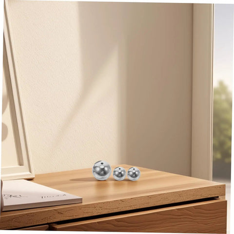 Small silver balls from Pendulum Ball Set For Classroom Physics And Science Education on wooden table in natural light