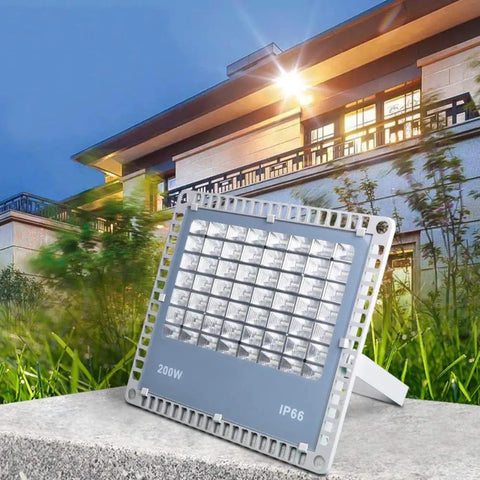 Heavy Duty 200W LED Flood Light With Tough As Nails Waterproof Housing For Yard Billboard And Deck Super Bright Outdoor Spot Lighting No Cap Badass Performance Rock Solid Build Hella Durable positioned in grassy area with modern building background.