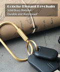 Locking Brass Carabiner Key Rings With Screw Lock Gold Tone Keychain Clip For Keys And Purses next to beige notebook