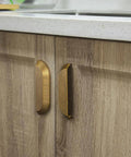 Six Pack 5 Inch Antique Brass Half Moon Cabinet Cup Handles For Kitchen Drawers And Cabinets installed on wooden cabinet.