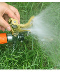 Hand adjusting Game Changing Garden Sprinkler With 360 Degree Rotating Irrigation System on grass, spraying water