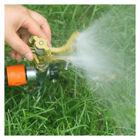 Hand adjusting Game Changing Garden Sprinkler With 360 Degree Rotating Irrigation System on grass, spraying water