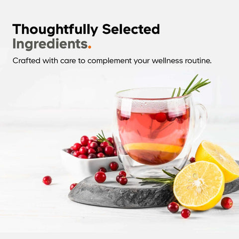 Glass cup of herbal tea with lemon slices, cranberries, and rosemary on stone slab, showcasing natural ingredients.