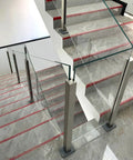 Built Different Stainless Steel Glass Railing Posts With Square Tube Design And Adjustable Heights For Indoor Hallways Outdoor Decks Pool Areas And Stairs Featuring A Rust Proof Brushed Finish That Keeps Your Property Secure And Looking Slick on modern staircase.