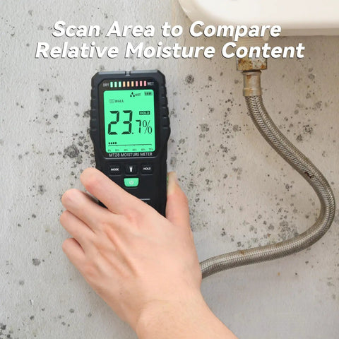 Hand using Moisture Meter For Wood And Concrete With Digital Tester And Pinless Sensor Three Color LCD Display on a wall.