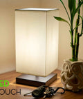Lucerna 13-Inch Modern LED Touch Table Lamp With Oil Rubbed Bronze Finish And White Fabric Shade on wooden table with keys