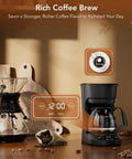 Compact 5 Cup Drip Coffee Maker With Programmable Timer, shown on a kitchen counter with coffee beans and cutting boards.