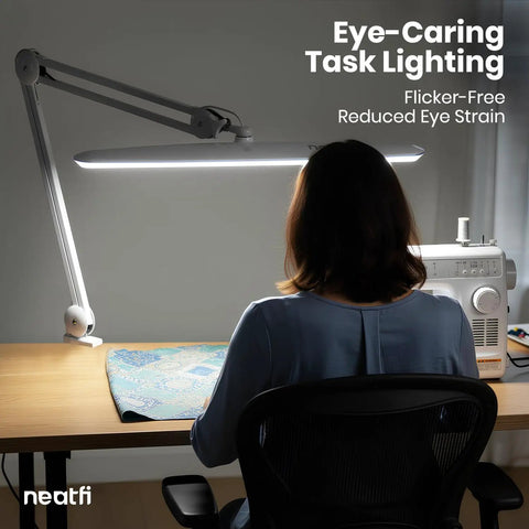 Person sits at desk with Monster Bright Desk Light With 2200 Lumens Of Crisp 6500K Daylight Glare Free Eye Care, sewing machine.