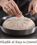 Person using Pro Grade Bread Lame Cutter Set For Home Bakers With 2 Sourdough Scorers to score dough in a pan