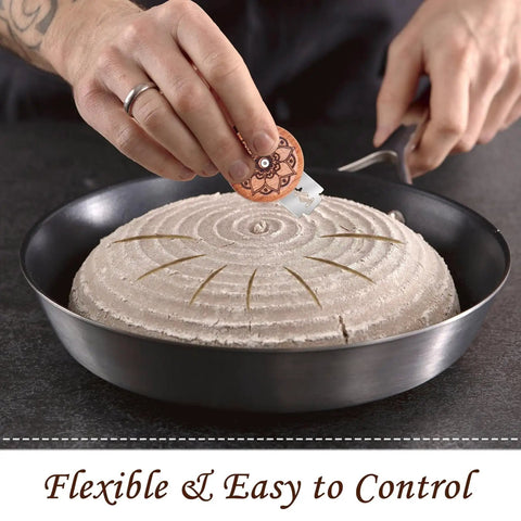 Person using Pro Grade Bread Lame Cutter Set For Home Bakers With 2 Sourdough Scorers to score dough in a pan