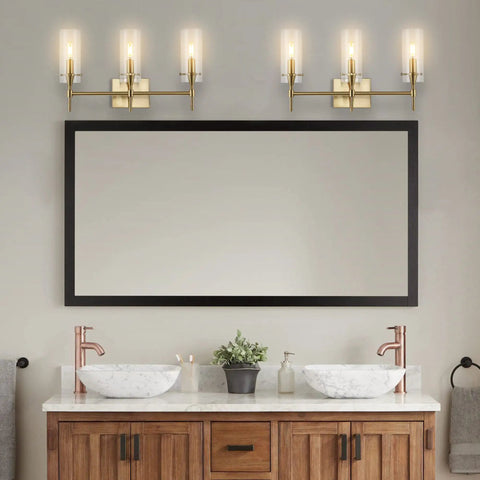 Brass Gold Modern Farmhouse LED Vanity Light Sconce With Clear Glass Cylinder Shade for bathroom over mirror with dual sinks.