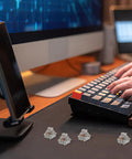 Ultimate Pro Grade Ten Piece Mechanical Keyboard Linear Actuators on a desk with hands typing on a black keyboard.