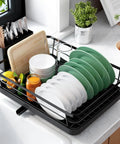 Compact Dish Drying Rack For Kitchen Counter Black Space Saving Drainer Holds 10 Plates And Bowls with green and white dishes drying.