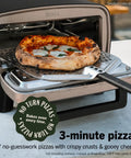 Backyard Pizza Oven With Stone 12 Inch Ready In Just 3 Minutes For Artisan Crusts With 700F Max Temperature Five In One Functionality Bake Broil Proof And Warm Makes Full Family Meals Outdoors For Your Cookout Gray MO201 displaying a baked pizza with crispy crust on a spatula.