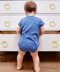 Child interacting with a dresser fitted with 4 Pack Gold Cabinet Knobs With Screws, Brushed Gold Ring Pulls For Dresser, Cupboard And Wardrobe.