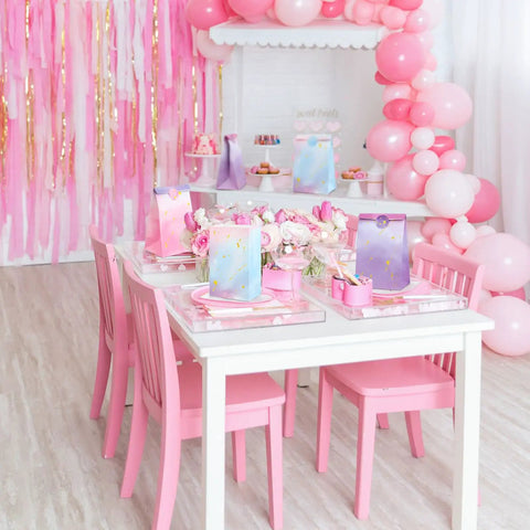Pink party setup with Tie Dye Party Favor Bags With 36 Stickers 30 Pack, pink chairs, table, balloons, and decorations.