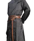 Snag This Fresh Medieval Faux Leather Wrap Belt To Kick Up Your Vintage Look With Adjustable Chain Details And A Snug Custom Fit That Elevates Your Everyday Streetwear Game Instantly. Brown faux leather belt with chain details worn over a black coat.