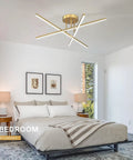 Gold LED Chandelier Three Lights Modern Semi Flush Mount Ceiling Fixture For Kitchen Dining Room Foyer Entry And Bedroom 24 Inches 25W Adjustable Arms For Custom Sleek Lighting in a bedroom setting with white walls and framed art.