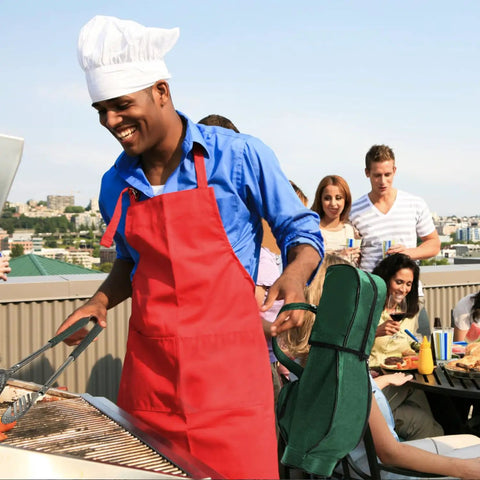 Man grilling on a rooftop with a group, using the Golf Themed 8 Piece Barbecue Grill Utensils Set With Golf Club Spatula Golf Ball Tongs And Two Golf Ball Salt And Pepper Shakers For Outdoor Cooking And Camping A Great Gift For Golf Lovers Men Women Dad Husband Grandpa.
