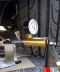 Pro Grade Two In One Brake Bleeder Kit With Handheld Vacuum Pump And Precision Pressure Gauge set up with fluid reservoir on driveway.