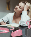 Woman writing with Sparkle Pink 4Pc Stapler And Tape Dispenser Set With Rhinestones Includes Pink Scissors And Staple Remover