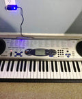 Casio LK-44 keyboard with a blue LED lit power adapter