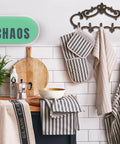 Knockout Five Hook Cast Iron Wall Hanger In Rustic Brown Fleur De Lis Farmhouse Entryway Coat Rack with striped kitchen towels.