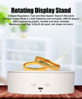 Heavy Duty Electric Rotating Display Stand With 6.6lb Load Capacity showing gold rings on a stable white base in a studio setting.