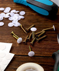 Plastic Self Tapping and Self Adhesive Screw Hole Covers for Wood Furniture, screws, covers, and tools on a wooden surface