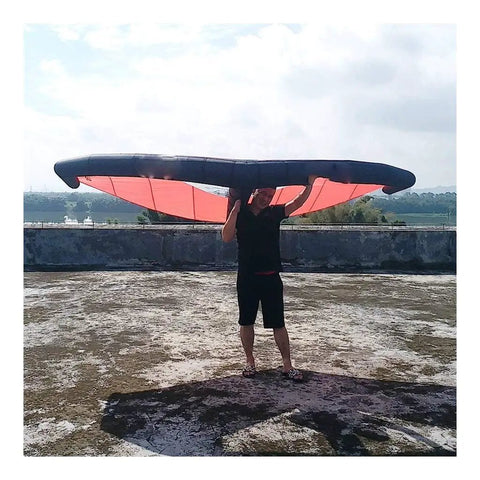 Person holding Handheld Inflatable Surf Wing for Windsurfing and Kiteboarding Do It All Water Sports Wing, TPU material, outdoor setting