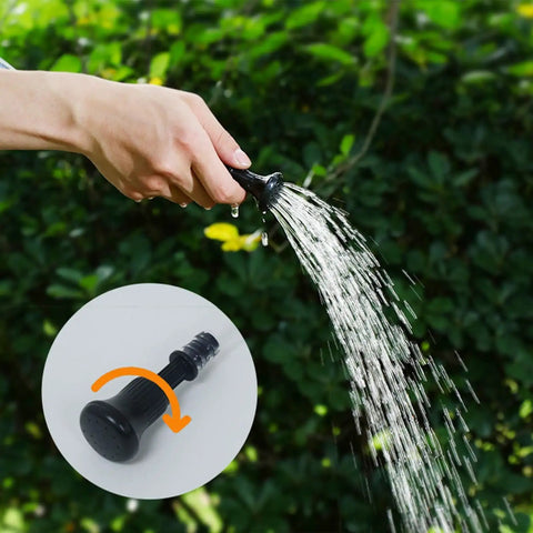 Hand holding nozzle of a 20L Capacity Heated Camp Shower Bag With Hose, Durable Fabric Portable Shower For Camping And Road Trips.