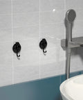 Heavy Duty Vacuum Suction Cup Hooks Black 2 Pack For Smooth Walls And Glass mounted on bathroom tiles holding towels.