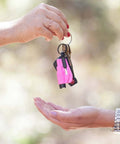 Pink resqme emergency keychain tool on a keyring with car keys, 2-in-1 seatbelt cutter and window breaker